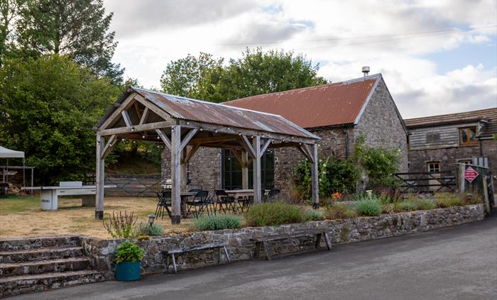 Exterior of open barn, grass terrace and stone barn at Welsh Lavender